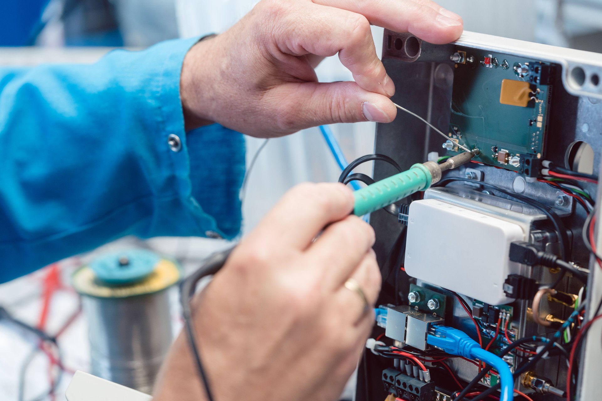 Electronics Engineer Man Troubleshooting Defects In A Hardware Product On His Test Bench