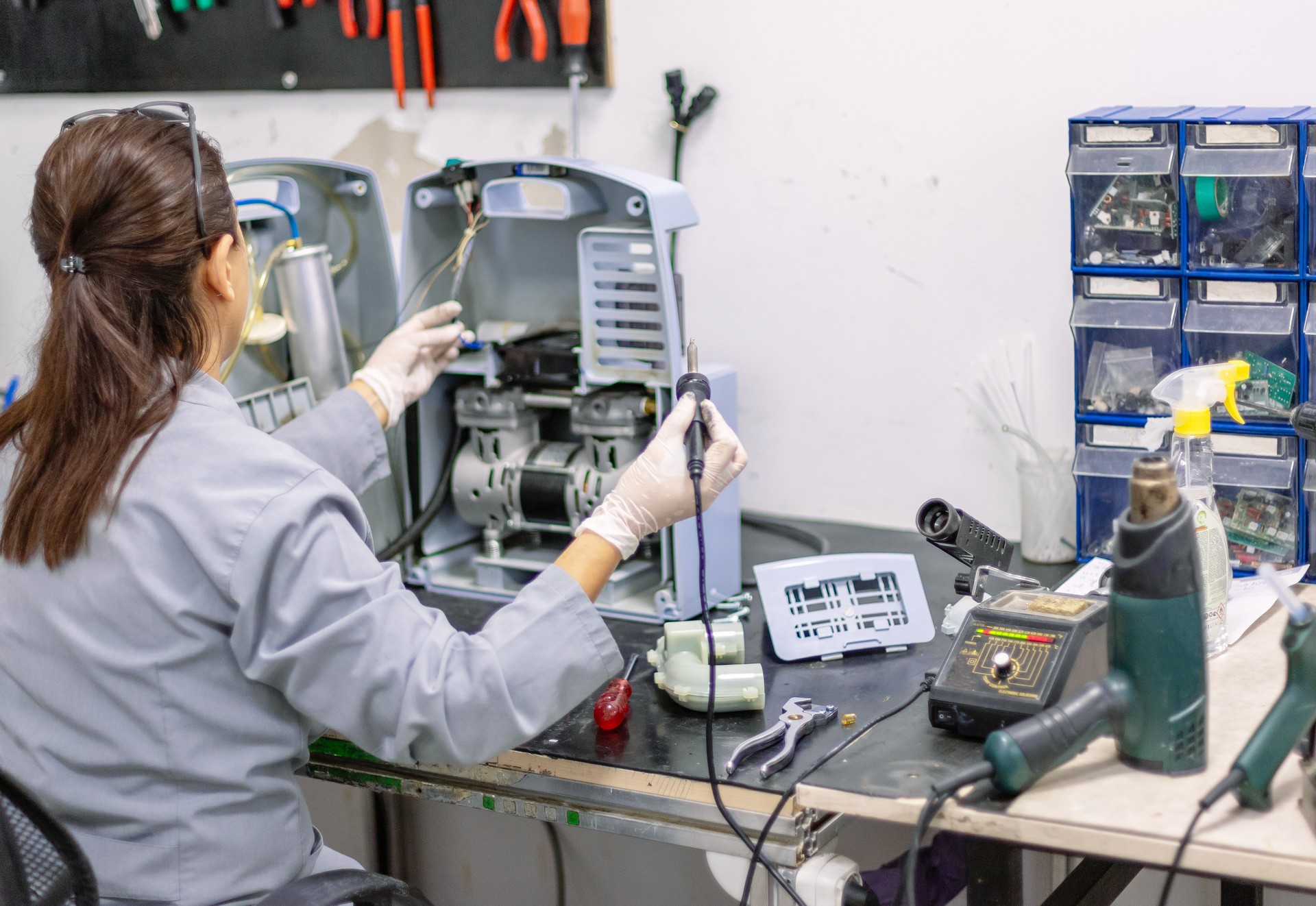 Woman soldering machine in workshop