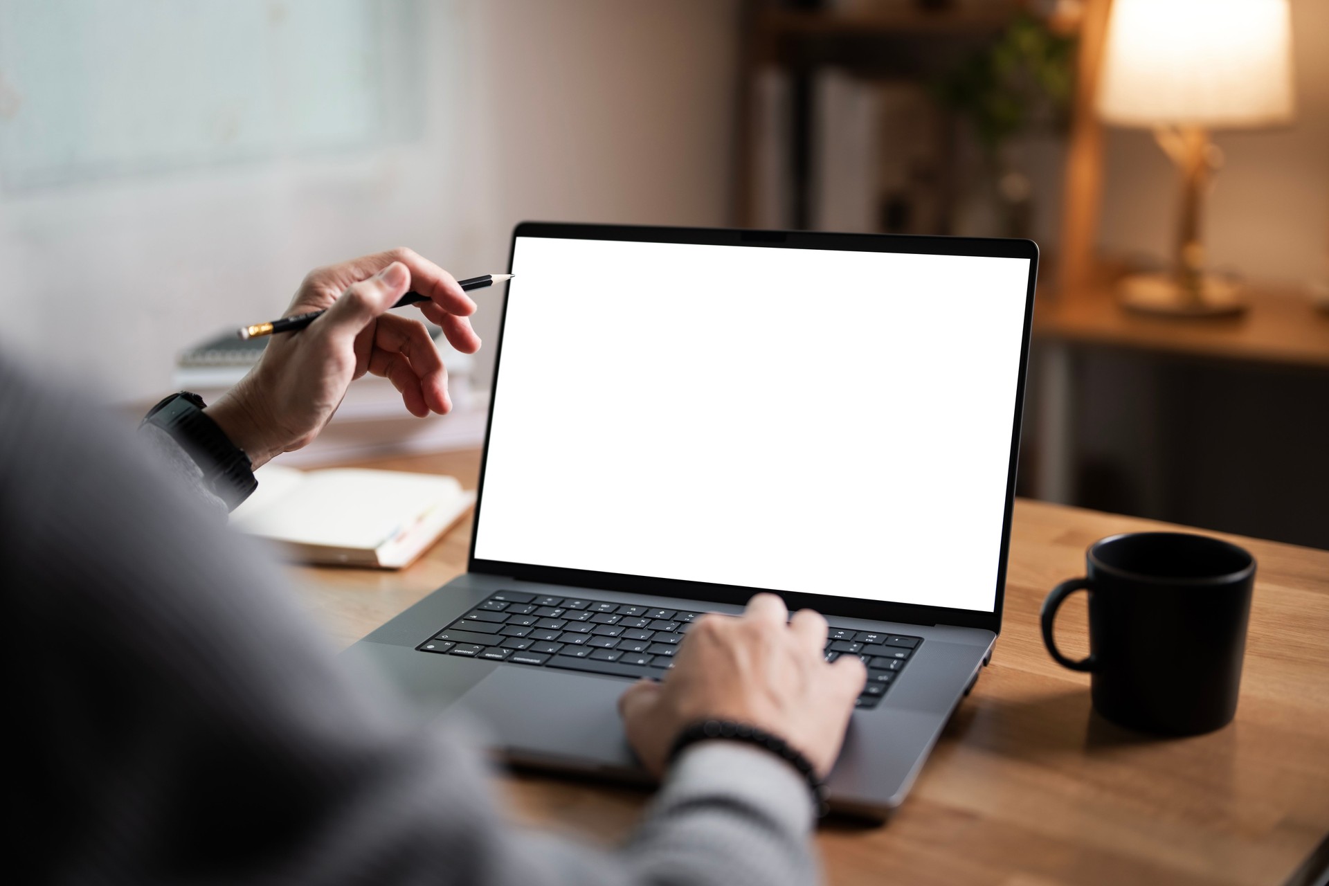 Man hand with blank white screen laptop, business man working on laptop computer at home office.