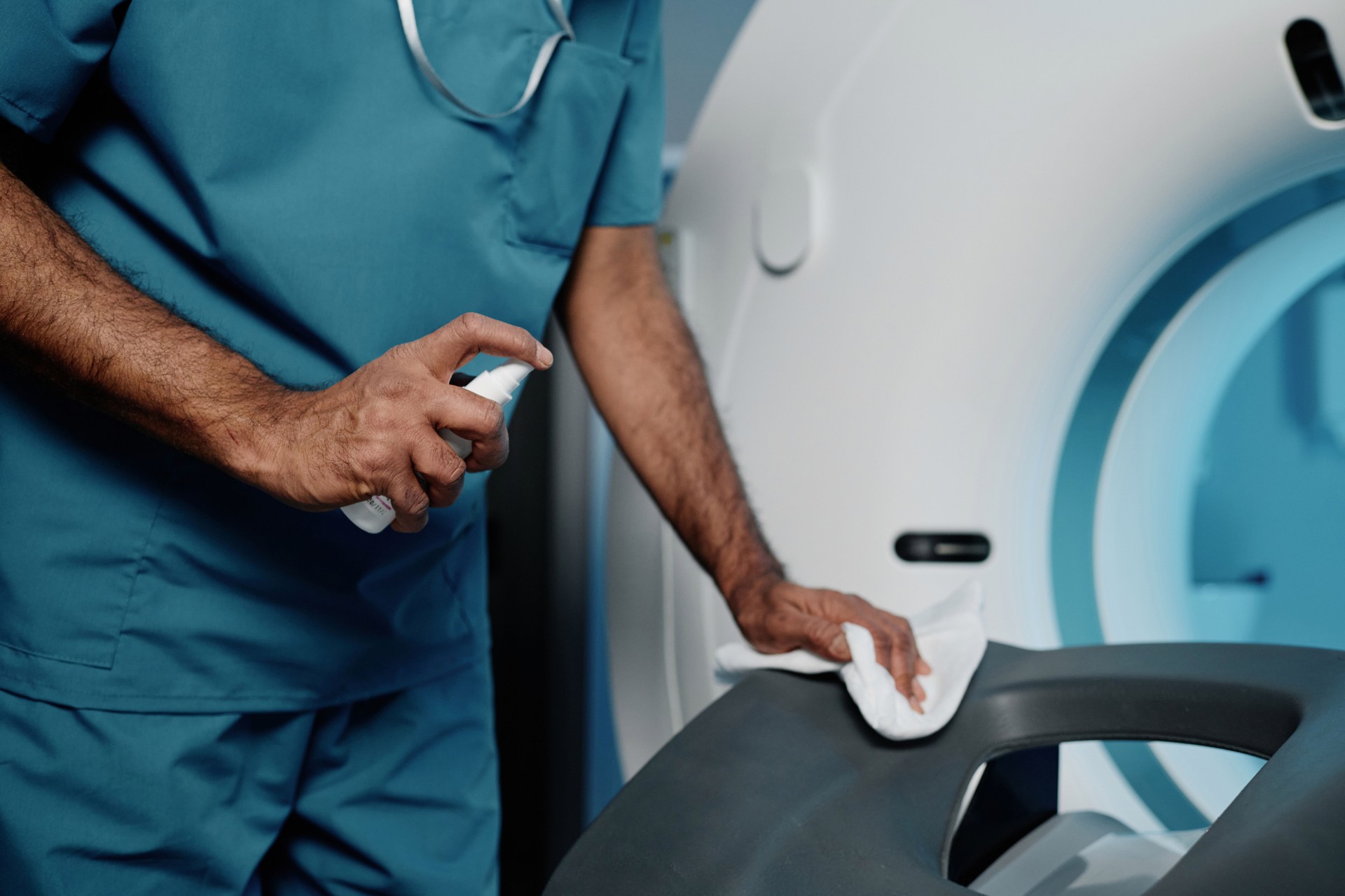 Radiographer Cleaning CT Scanner Bed